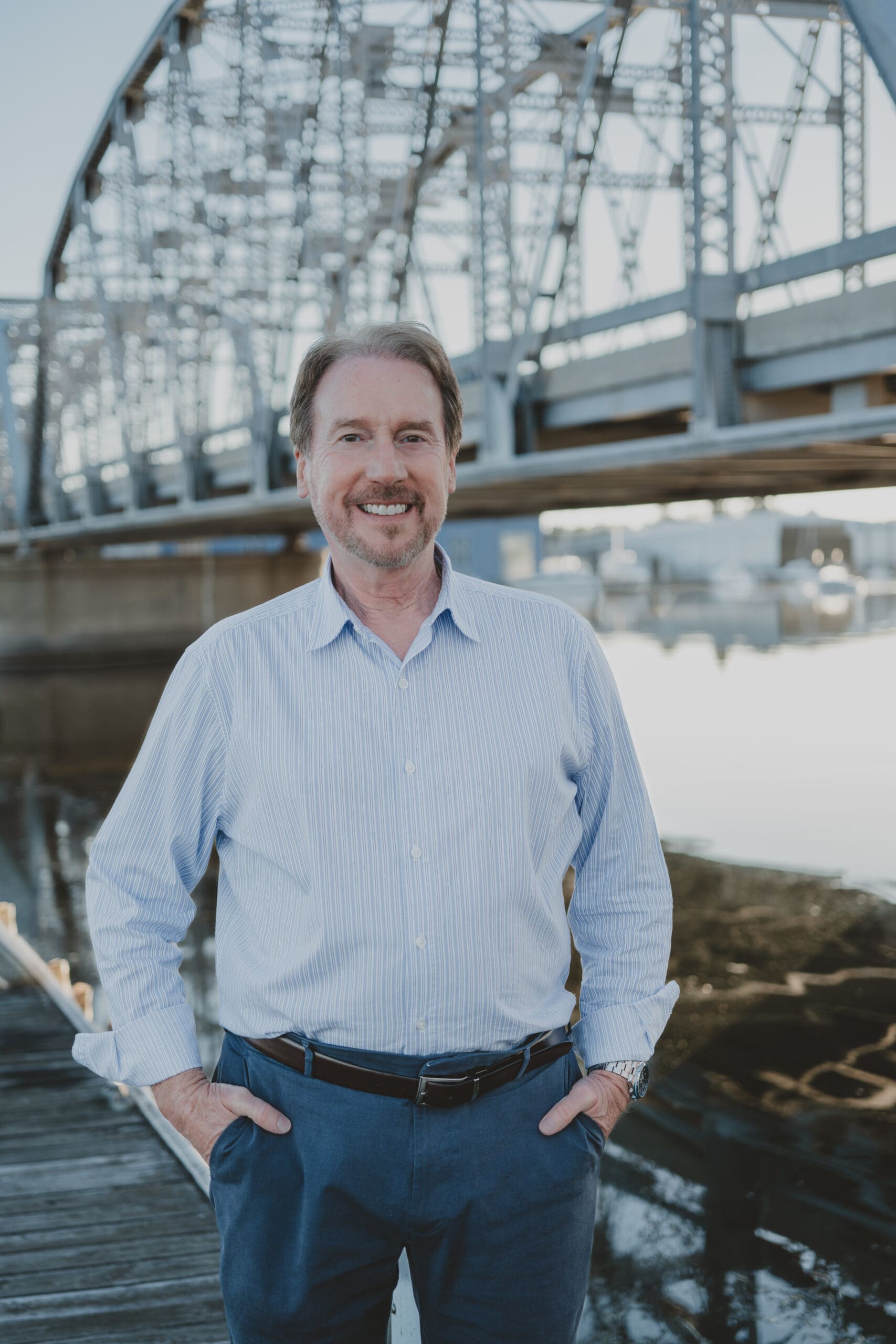 Author C.B. Shutt standing with the Old Steel Bridge in the background.